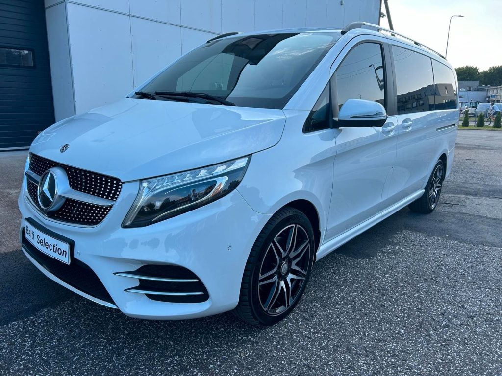 Außenansicht des weißen Mercedes-Benz V 300 AMG Exclusive Edition Lang BURMESTER. Zu sehen ist die Fahrerseite und die geschlossene Motorhaube.